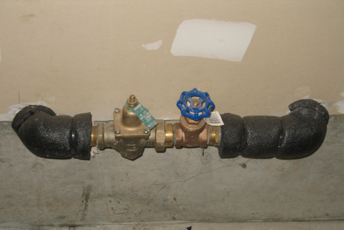 Photo of a water service line where it enters the home including the shut off valve